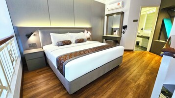 Une chambre d’hôtel moderne avec un grand lit, des tables de chevet, un miroir et un appareil de climatisation.