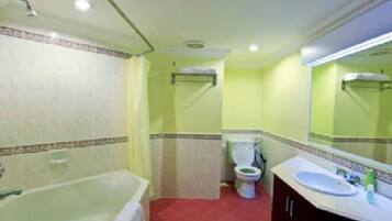 A bathroom with a bathtub, toilet, and sink.