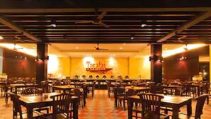 Un restaurant avec plusieurs tables et chaises, un sol à motifs et une enseigne indiquant « Teratai ».
