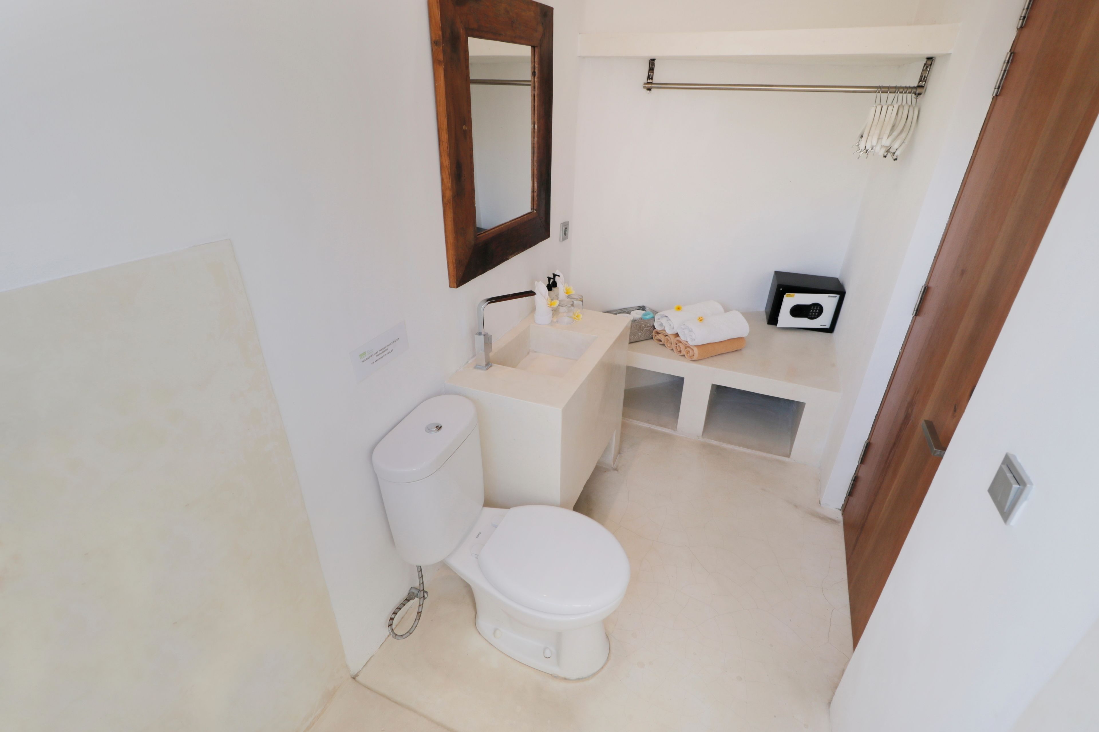 Un baño pequeño y limpio con inodoro, lavabo y espejo.