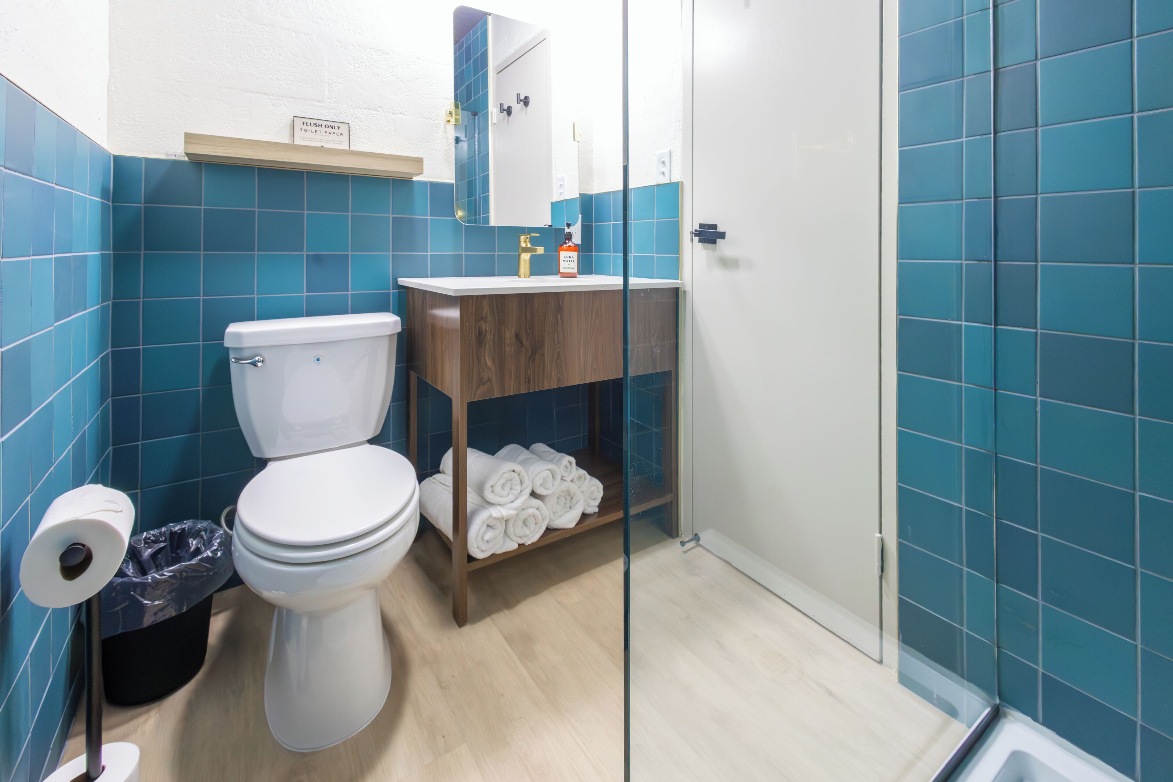 A bathroom with a toilet, a sink, and a glass shower enclosure.