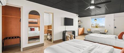 A modern hotel room with two beds, a TV, a ceiling fan, and a window with a view.
