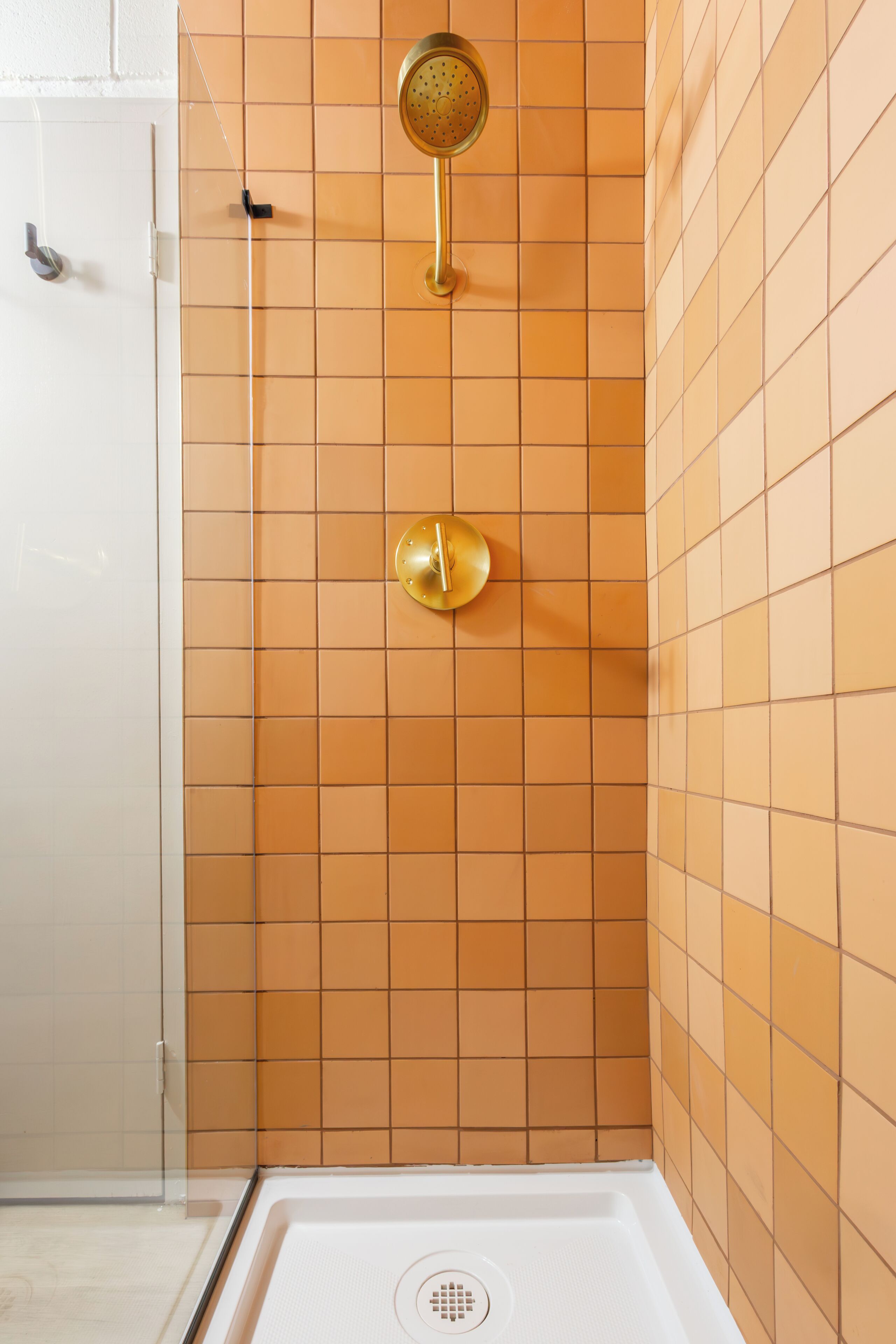 Eine Dusche mit Brausekopf und Bedienfeld, beides in Gold.