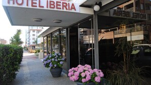 A hotel entrance with a sign reading "HOTEL LIBERIA," large potted plants, and a clear view of the street. - Hotel 24 (Punta del Este)