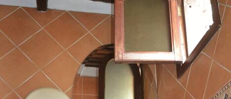 Un baño con un lavamanos blanco, un espejo y un dispensador de jabón.