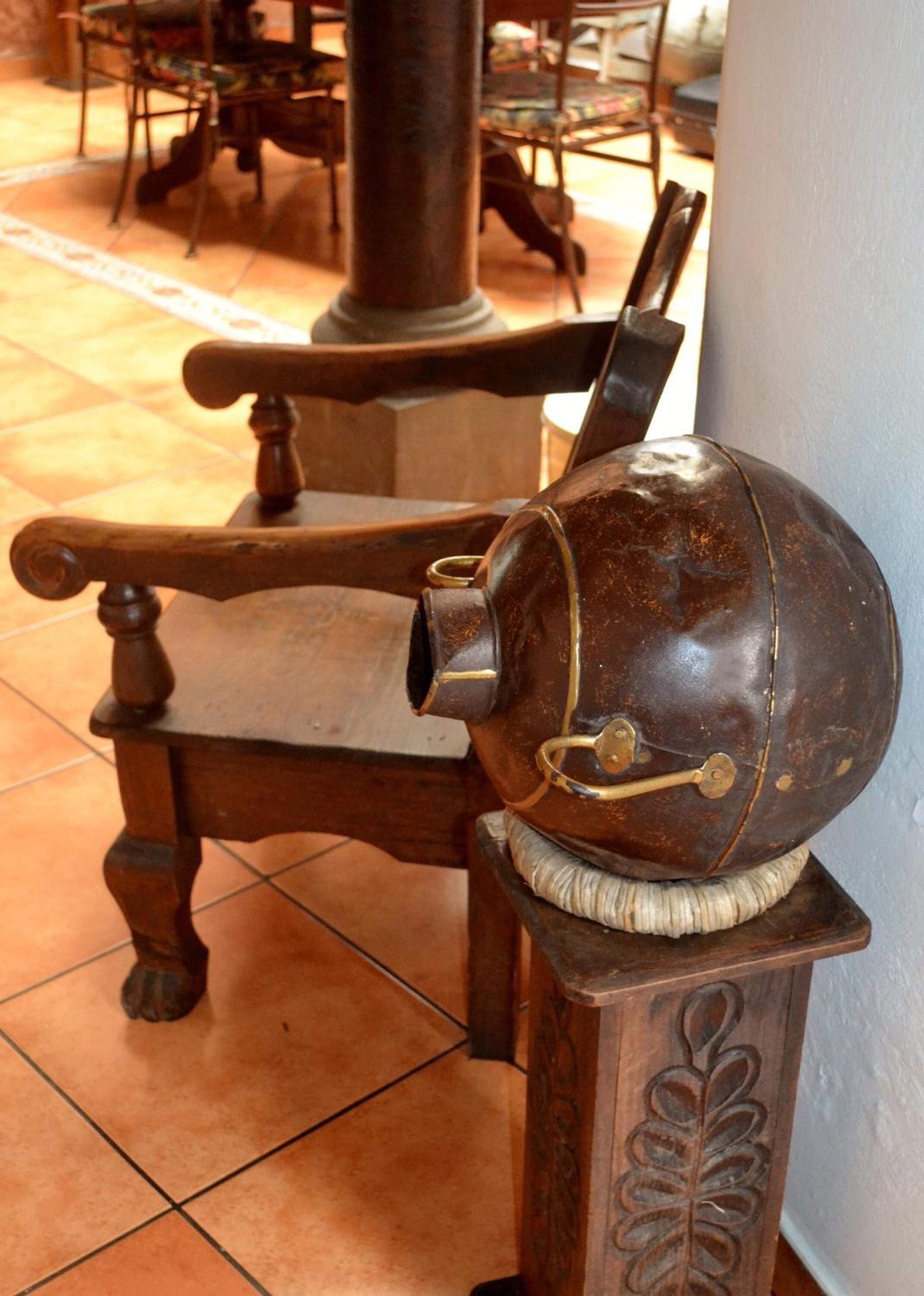 A wooden chair with a metal object on its backrest.