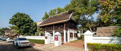 A traditional building with a thatched roof, a white fence, and a sign indicating it is Victoria Xietong Palace.