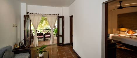A hotel room with a bed, a ceiling fan, and a view of the outdoors.