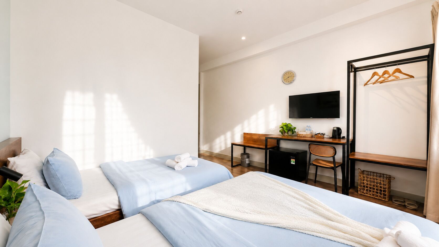 Una habitación de hotel con cama, escritorio, televisor y armario.