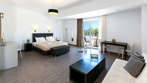 Una habitación de hotel moderna con cama, escritorio, sofá y balcón con vistas.