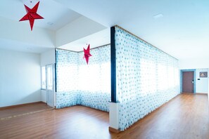 Una habitación amplia con suelo de madera, un ventanal grande y una puerta.