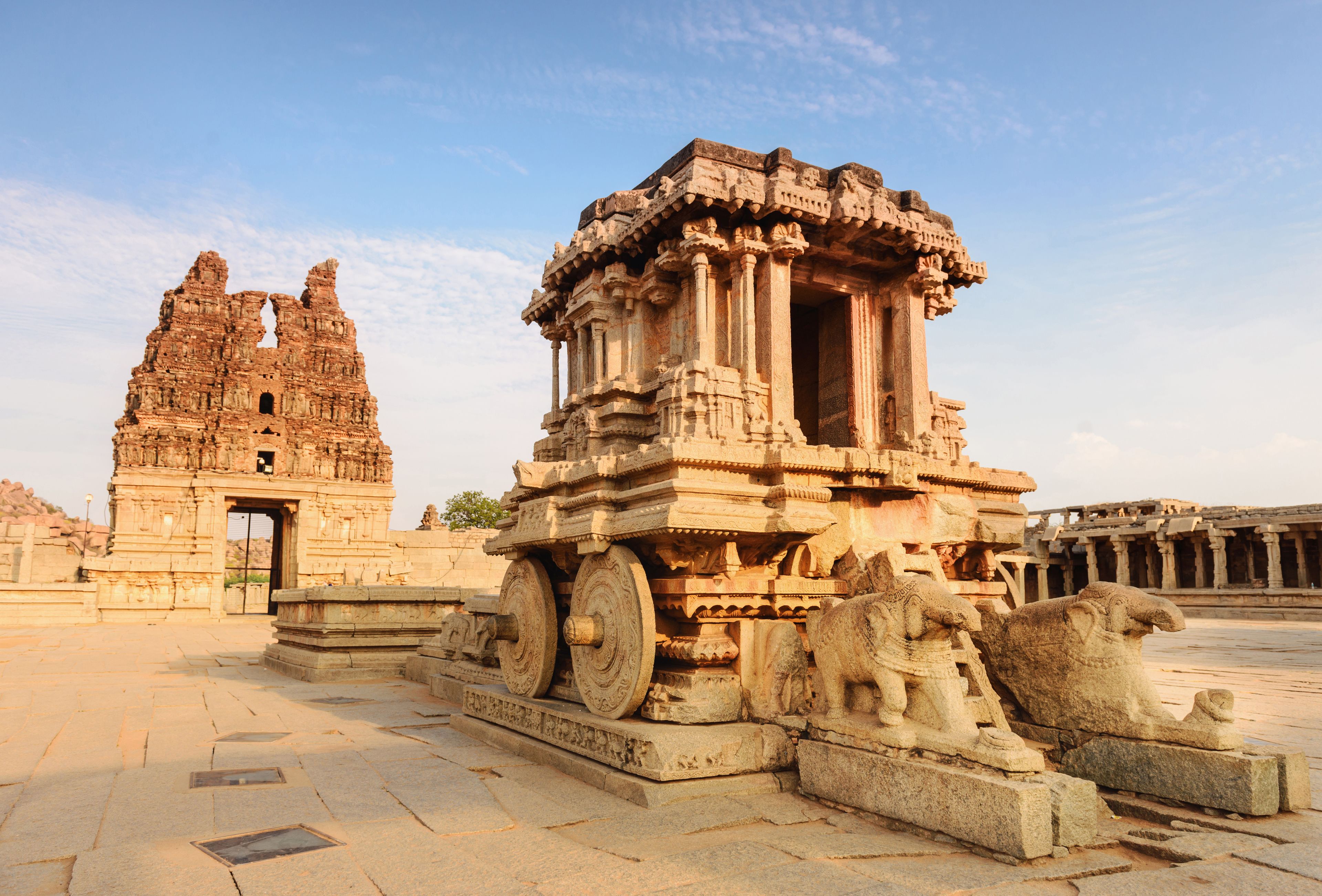 Ancient stone structures with intricate carvings and a large wheel-like base.