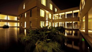 Un bâtiment moderne à étages, doté de grandes fenêtres et d’une façade bien éclairée.