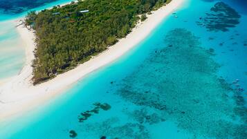 Di pantai, pasir putih, dan handuk pantai