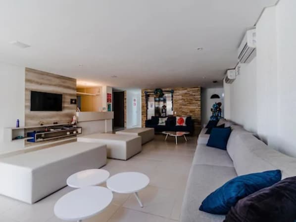 A modern living room with a flat-screen TV, a sofa, and a coffee table.