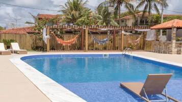 Una piscina al aire libre, tumbonas