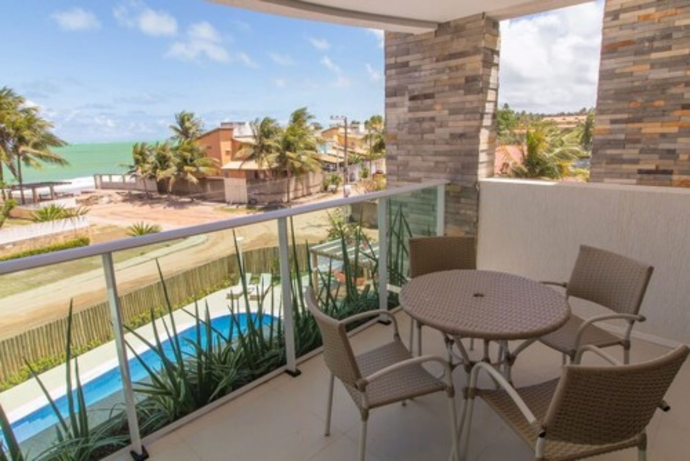 Un balcone con vista su una spiaggia e una piscina.