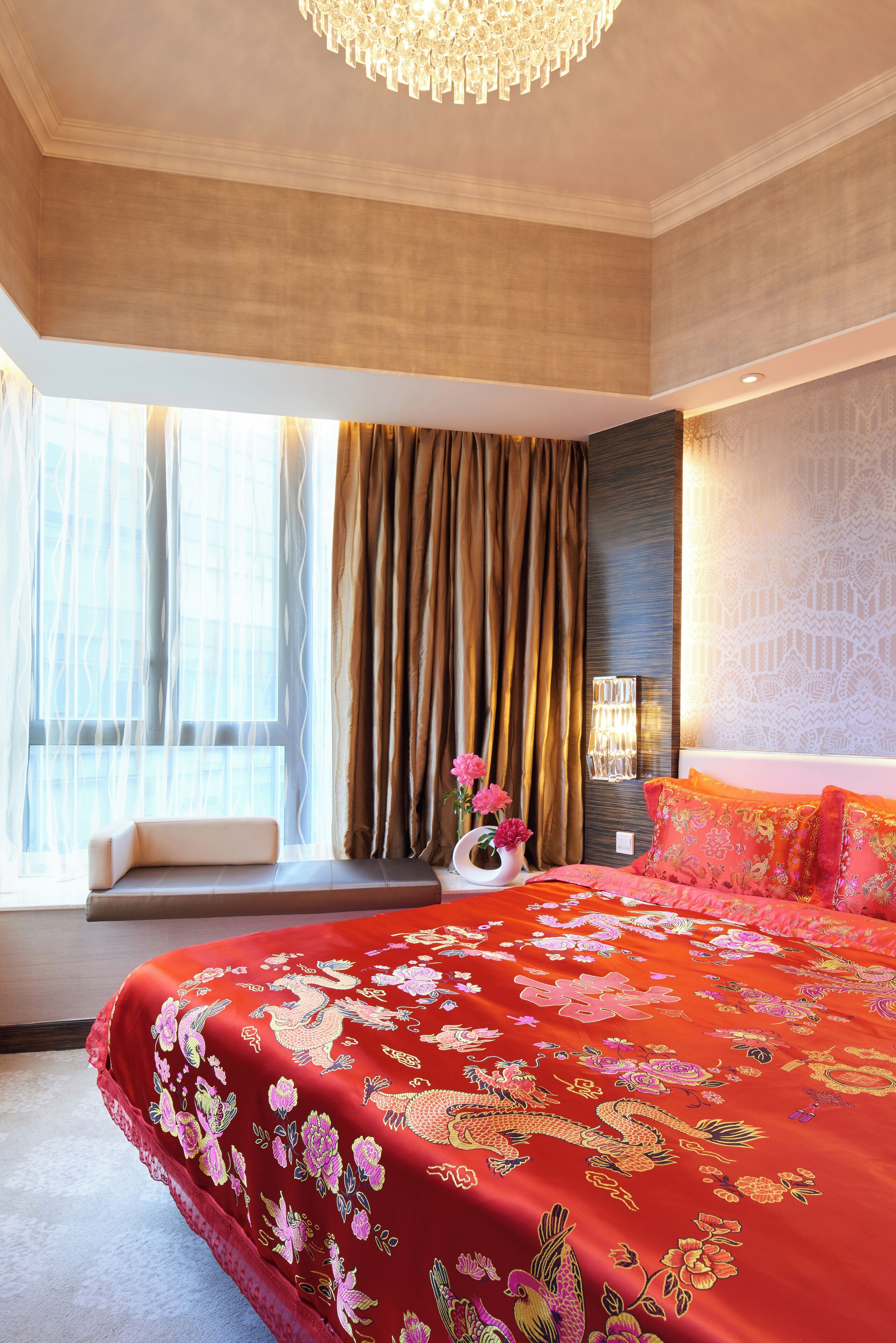 Quarto de hotel com uma cama grande, um banco junto à janela e um abajur decorativo.