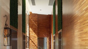 Un interior moderno con paneles de madera, detalles verticales verdes y un suelo limpio y reflectante.