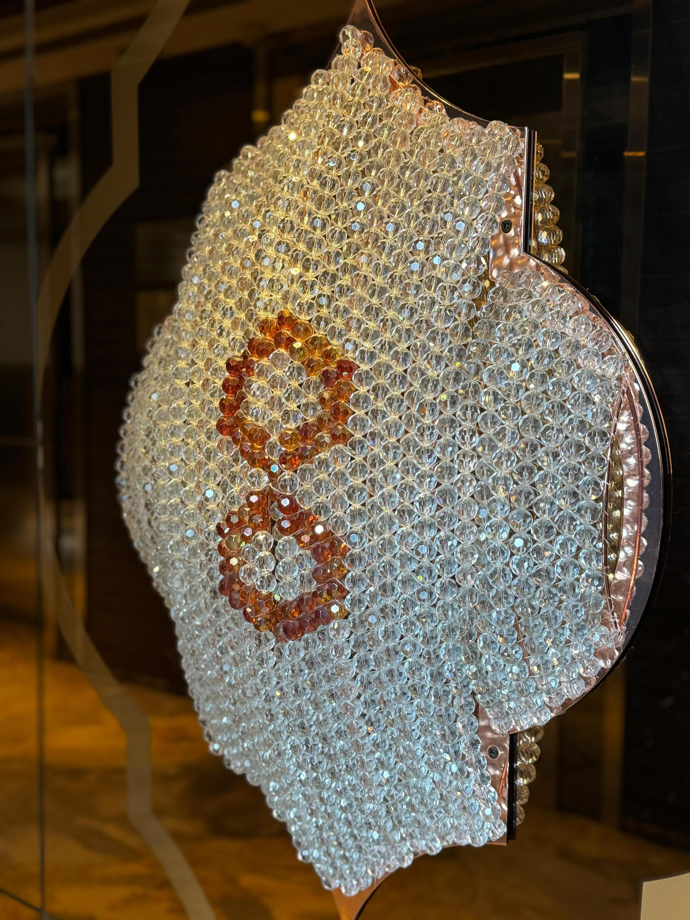 A decorative glass art piece with a geometric pattern and a number '8' in the center.