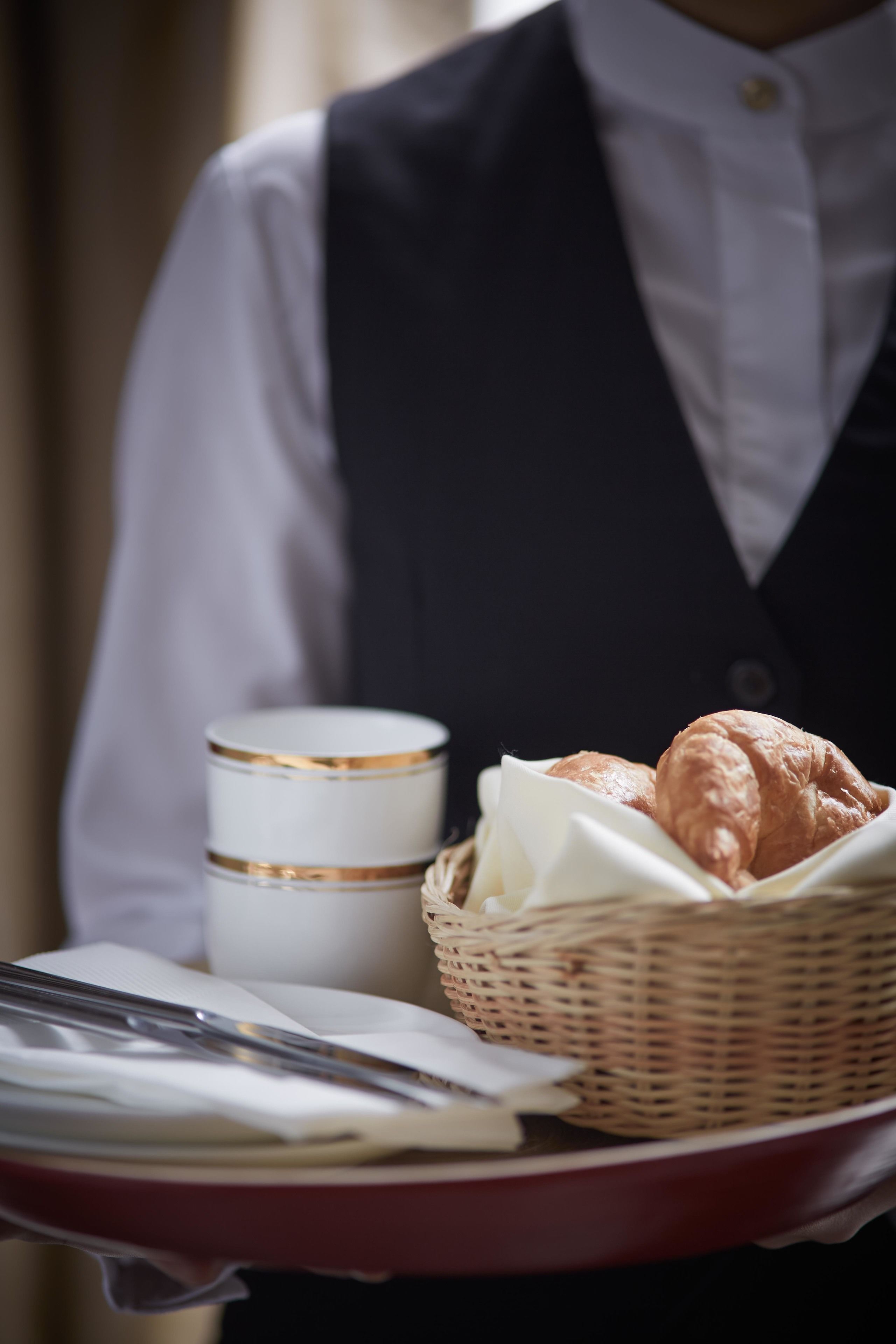 A tray with a croissant, a cup, and a knife.