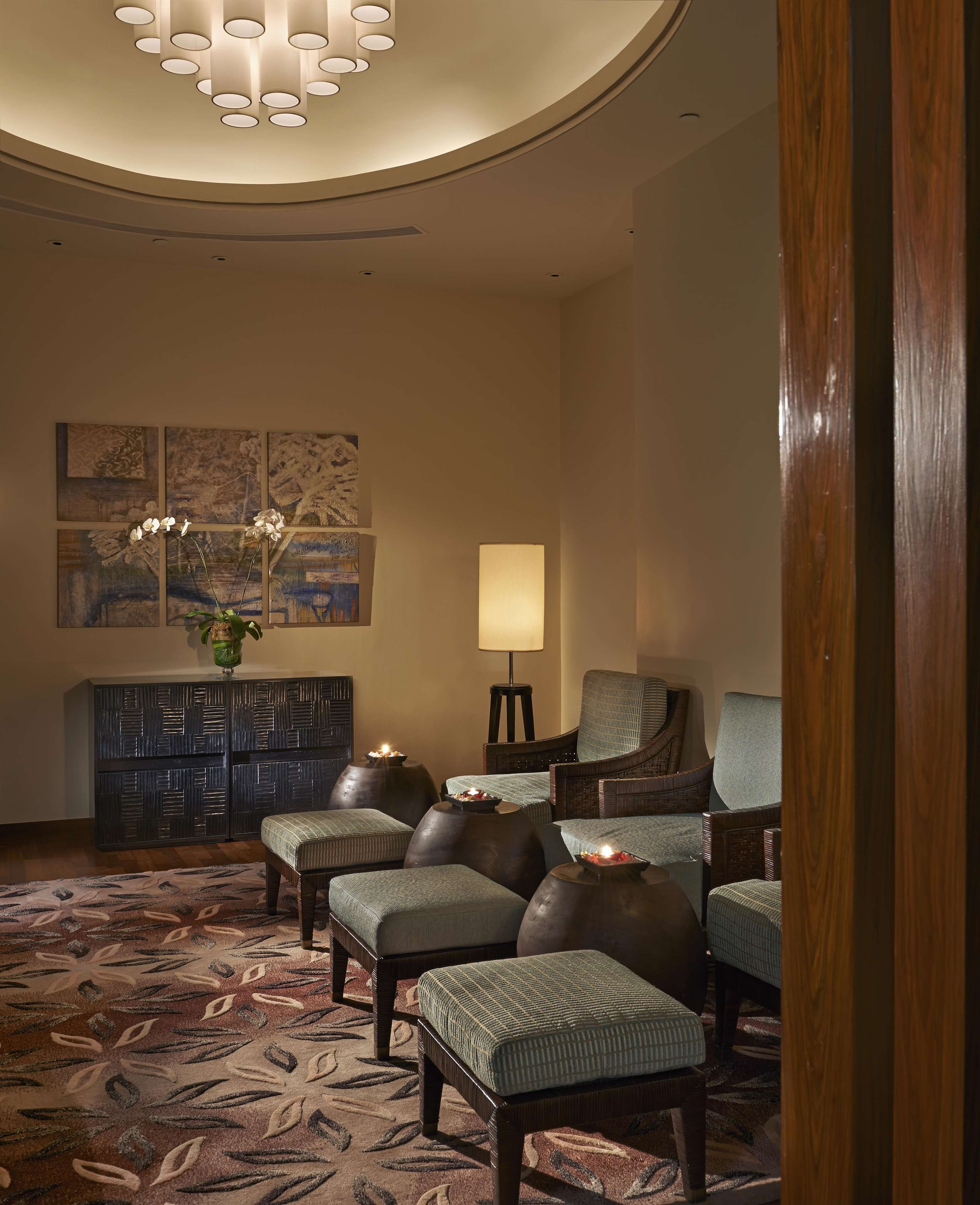 A lobby with a seating area, a reception desk, and artwork on the wall.