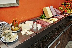 A buffet with various cheeses, meats, and fruits. - Hotel Metropolitan (Campo Grande)