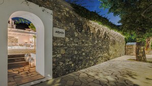 A stone wall with a sign reading "AIONOS HOTEL BAR". - Aeolos Hotel & Villas -Pelion (Zagora-Mouresi)