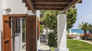 An outdoor seating area with a wooden pergola, a table with a woven basket, and a view of the sea. - Aeolos Hotel & Villas -Pelion (Zagora-Mouresi)