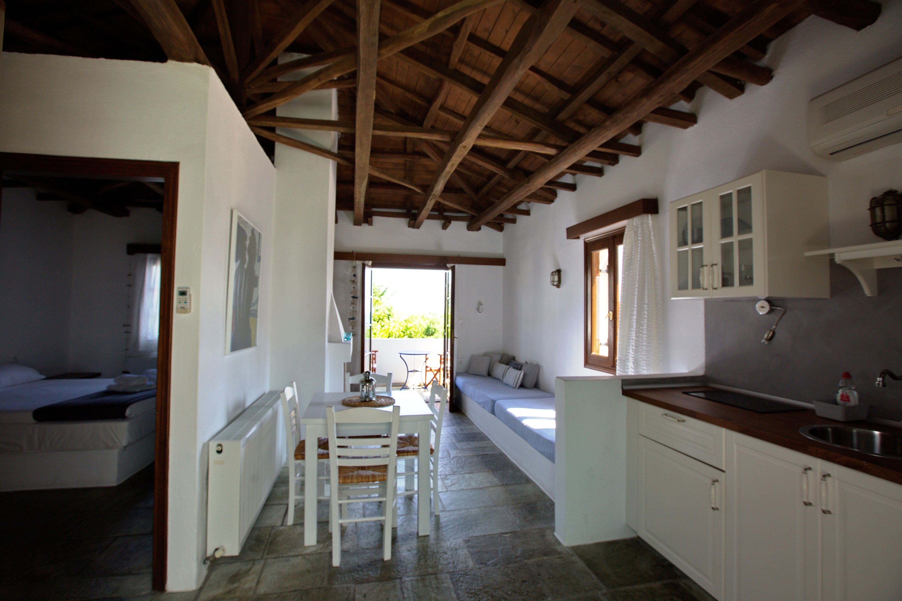 A compact kitchen with white cabinets, a wooden countertop, and a built-in sink.