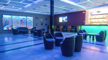 A lobby with wicker chairs, a reception desk, and a large aquarium wall.