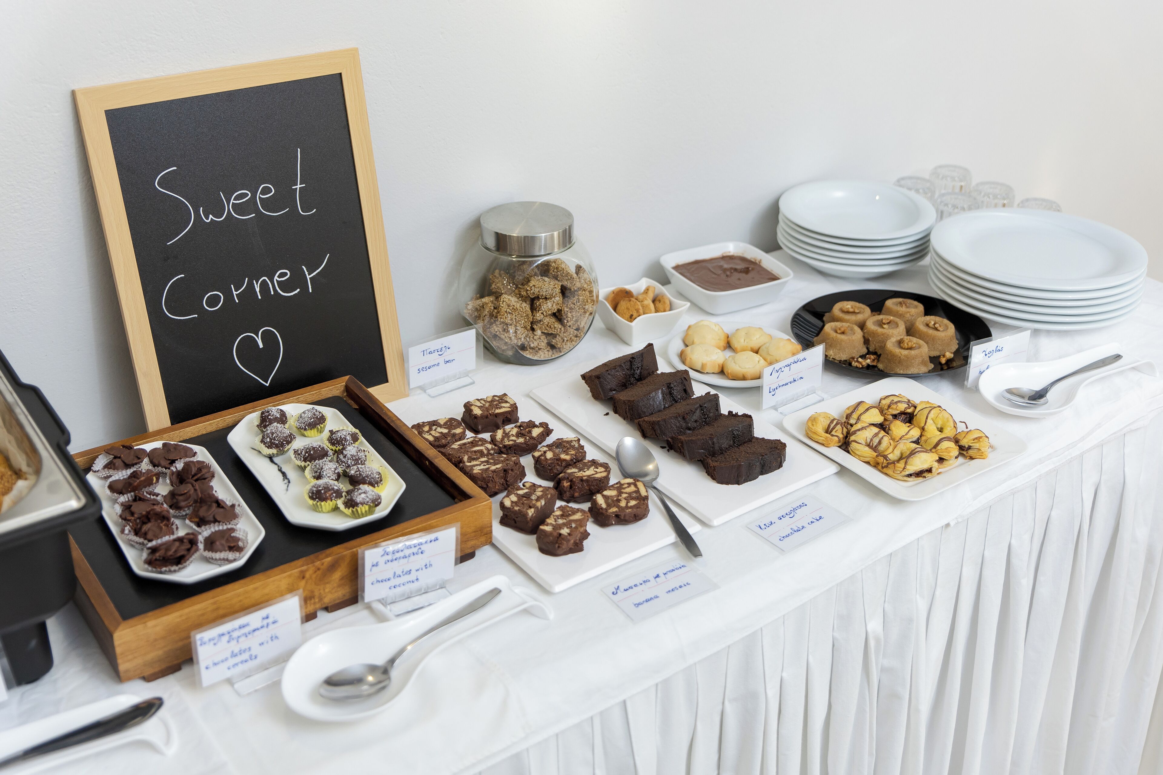 A buffet table with various desserts and a sign reading "Sweet Corner".