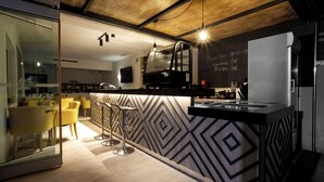 A modern kitchen with a blackboard displaying the coffee shop hours. - Athina Beach Hotel (Chania)