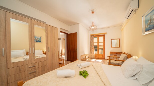 Ein Hotelzimmer mit einem großen Bett, einem Kleiderschrank, einem Schreibtisch und einem Stuhl.