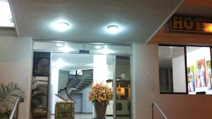 A hotel entrance with a staircase leading to the lobby, a potted plant, and a sign indicating the hotel's name. - Hotel Betoma (Santa Marta)