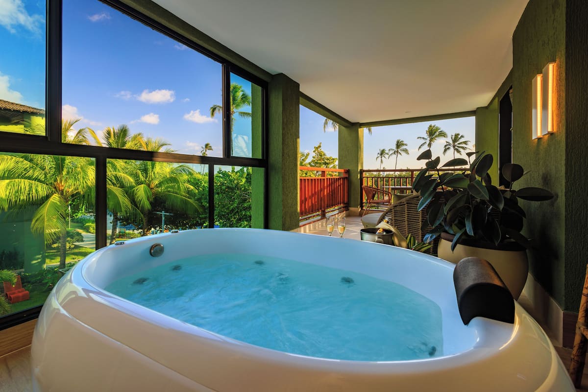 A hot tub with a view of palm trees and a balcony.