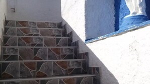 Uma escadaria com degraus de pedra conduzindo a uma parede branca.