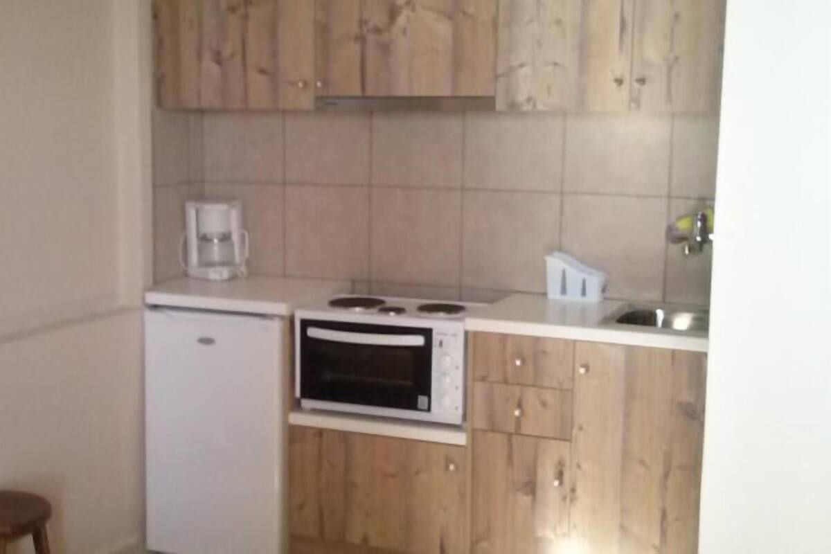 A small kitchen with a refrigerator, microwave, and stove.