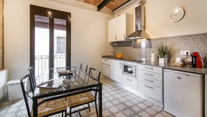 Una cucina moderna con mobili bianchi, forno integrato e macchina da caffè.