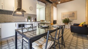 Una cucina moderna con mobili bianchi, piano cottura integrato e un'ampia finestra.