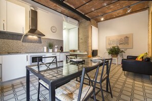 A modern kitchen with white cabinets, a built-in stove, and a large window.