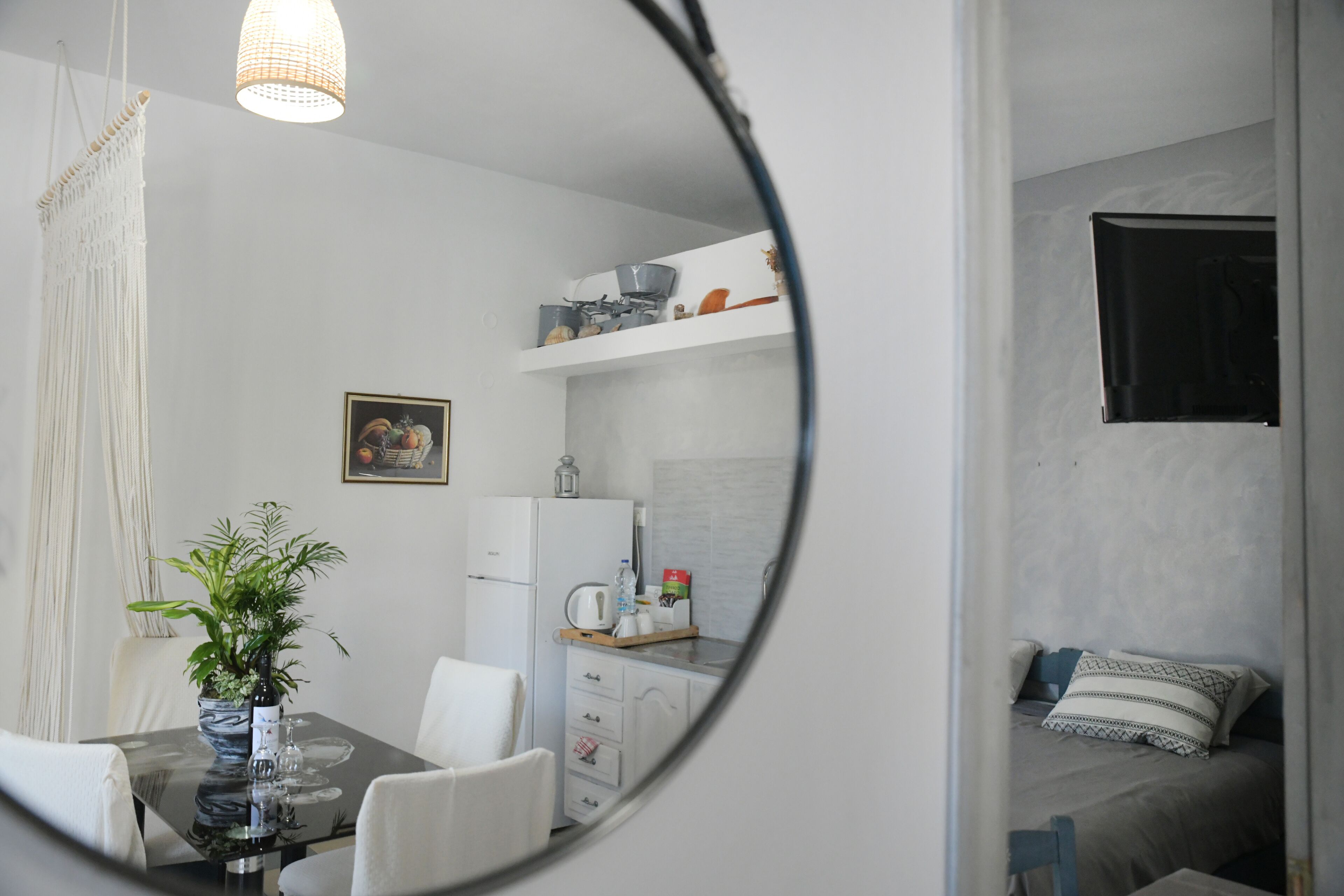 A compact living space with a dining area, kitchenette, and a bed.