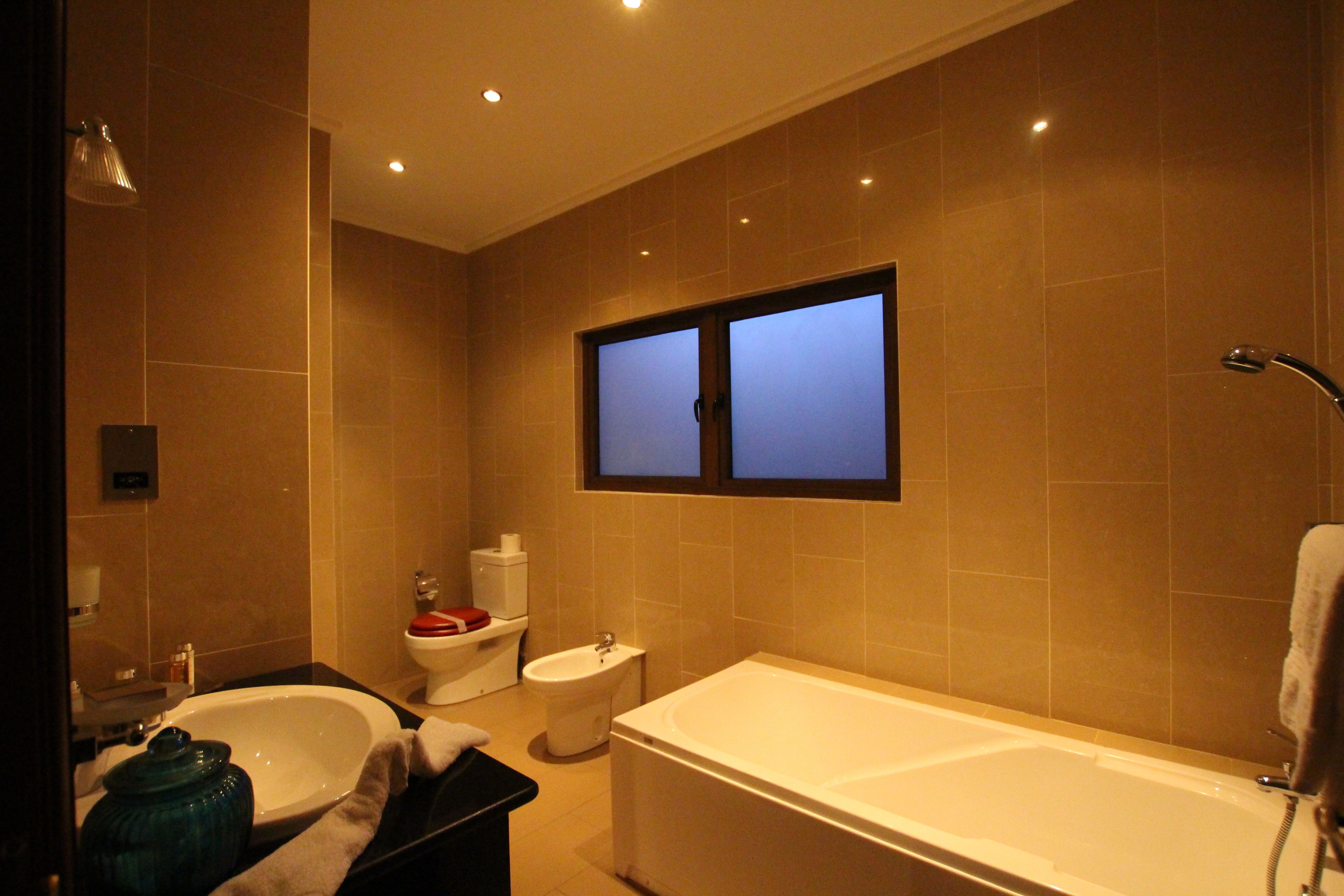 A modern bathroom with a bathtub, toilet, and sink.