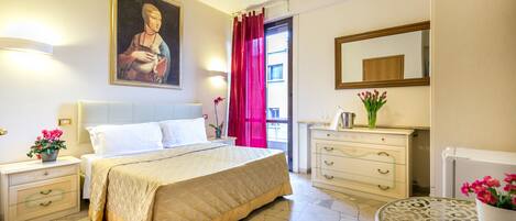 Un dormitorio con una cama grande, mesitas de noche, un aparador, un espejo y una ventana con cortinas rojas.