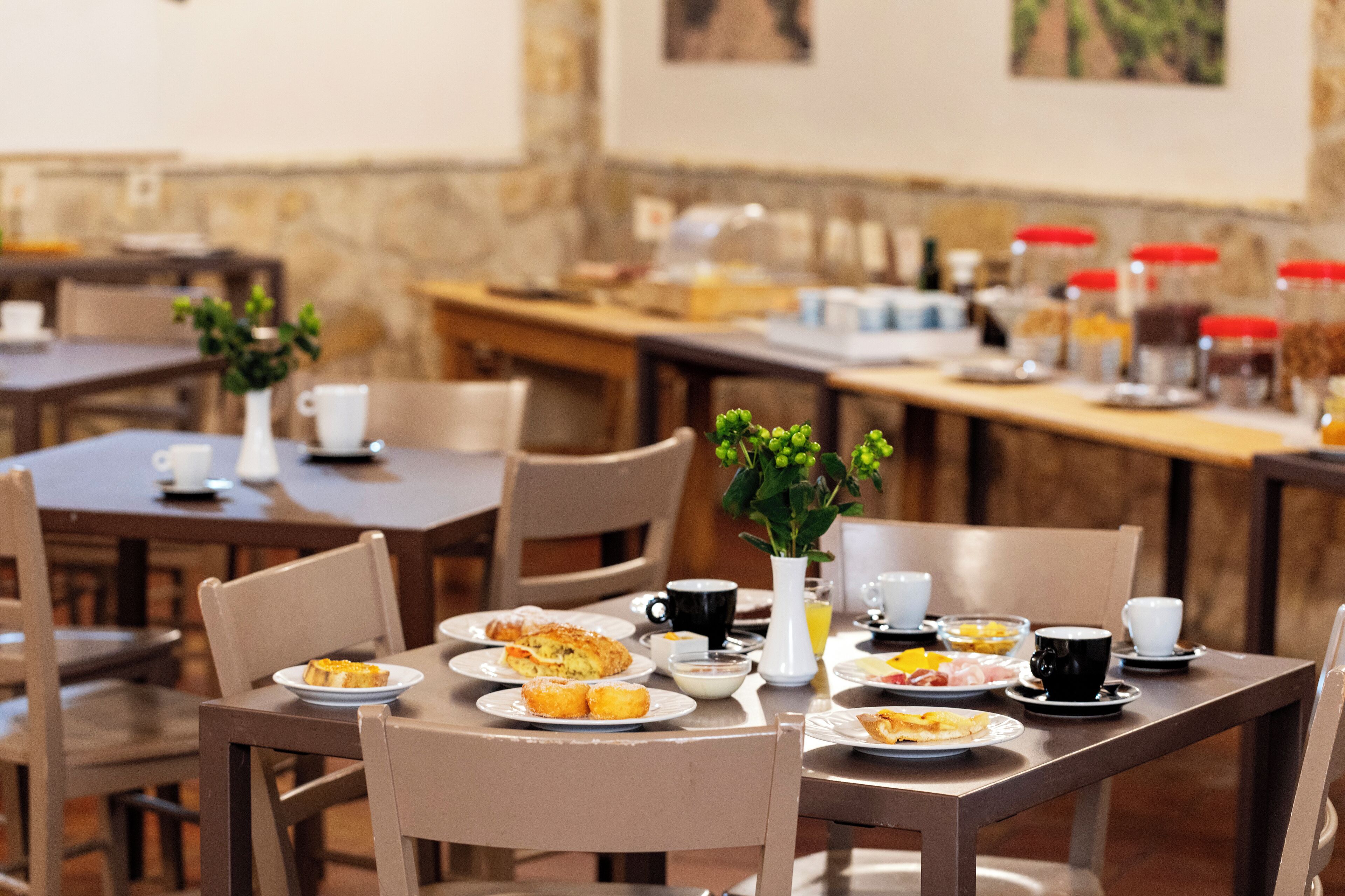 Ein Frühstücksbuffet mit Tischen, Stühlen und einer Auswahl an Speisen und Getränken.