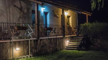 Um edifício com varanda, área de estar ao ar livre e escadaria que leva à entrada.