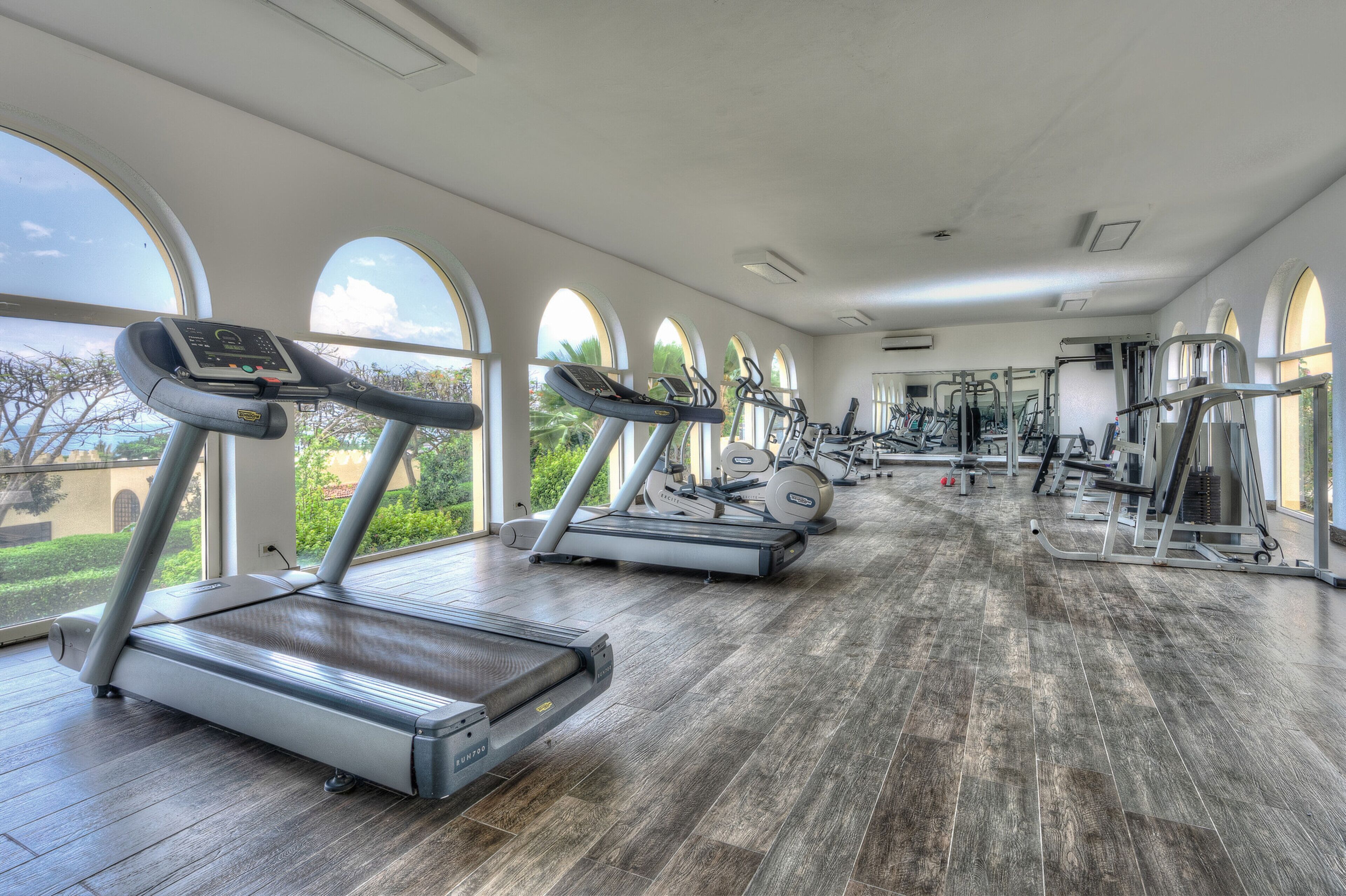 A gym with treadmills, elliptical machines, and weight equipment.