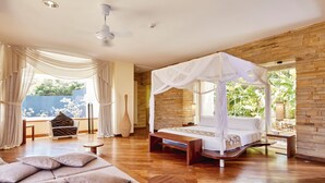 A spacious bedroom with a canopy bed, a sitting area with a chair and table, and a view of greenery outside. - Hotel Riu Palace Zanzibar - All Inclusive (Nungwi)