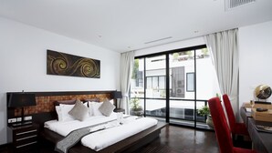 Una habitación de hotel moderna con una cama grande, un escritorio y vistas al exterior.