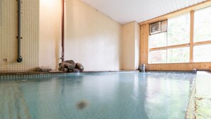 A large indoor swimming pool with tiled walls and a wooden ceiling. - Villa Alpen (Yamanouchi)